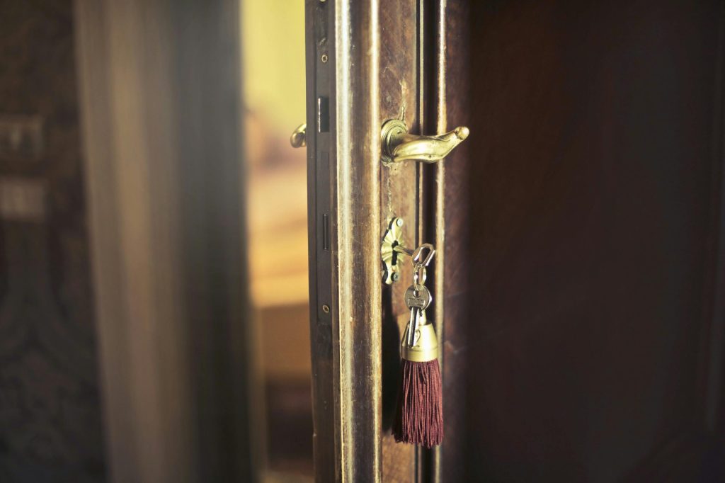 a brown door open and hanging key on it